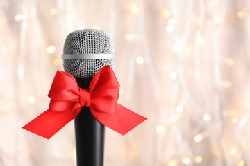 Microphone with bow on blurred background. Christmas music concept