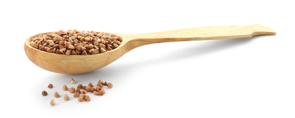 Spoon with raw buckwheat on white background. Healthy grains and cereals