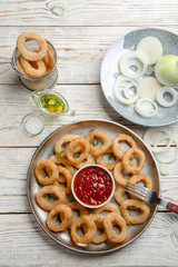 Flat lay composition with onion rings on wooden background
