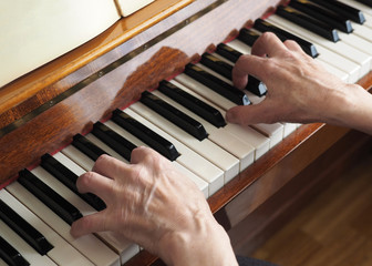 Elderly person hand playing the piano, close up