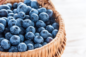 Blueberry in basket on wooden table background. Ripe and juicy fresh picked blueberries closeup