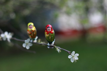Matreshka is on a bench with dof. Russian doll is in nature.