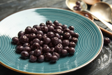 Plate with fresh acai berries on table, closeup