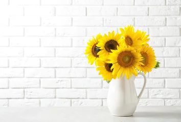 Tuinposter Jug with beautiful yellow sunflowers on table © New Africa