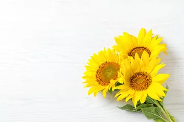 Foto op Plexiglas Gele zonnebloemen op houten ondergrond, bovenaanzicht © New Africa