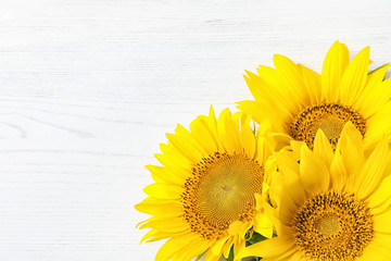 Yellow sunflowers on wooden background, top view