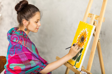 Portrait of gorgeous woman artist painting in art studio