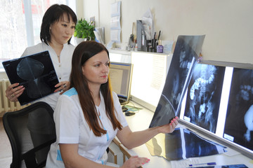 Doctors radiologists work in the laboratory with X-ray photographs.