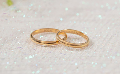 Obraz na płótnie Canvas Two golden wedding rings on white shiny background