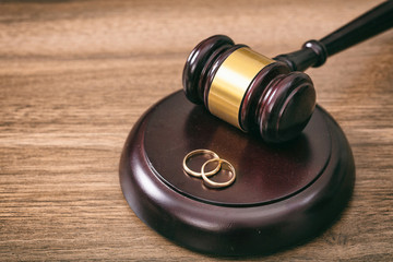  Wedding rings and judge gavel on wooden background, copy space