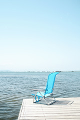 blue deck chair on a pier