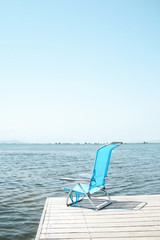 Fototapeta premium blue deck chair on a pier