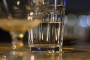 Gglass of water half-full standing on wooden table