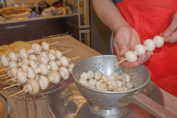 hands only view of oman in apron, preparing for a healthy organic vegetarian meal with mushrooms...