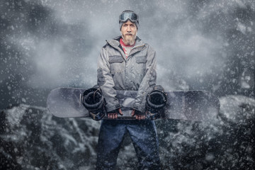 Brutal redhead snowboarder with a full beard in a winter hat and protective glasses dressed in a...