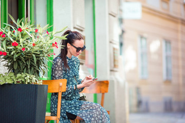 Woman talk by her smartphone in city. Young attractive tourist outdoors in italian city