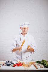 Chef. Paste. Ingredients. Recipes of Italian cuisine. Food concept. Preparing traditional italian dish. Food concept. Preparing traditional italian dish. Smiling chef in white uniform and white hat.