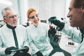 Trio of workers. Trio of smiling professional medical workers feeling happy while enjoying...