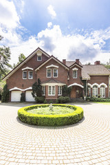 Round garden and paving in front of a big, english style house