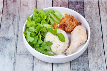 Streamed oily Jasmine rice and streamed chicken call as Hainanese chicken rice and deep fried chicken topped mixed vegetable.