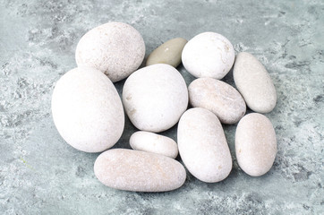 Fototapeta na wymiar Round light sea stones on gray blue background