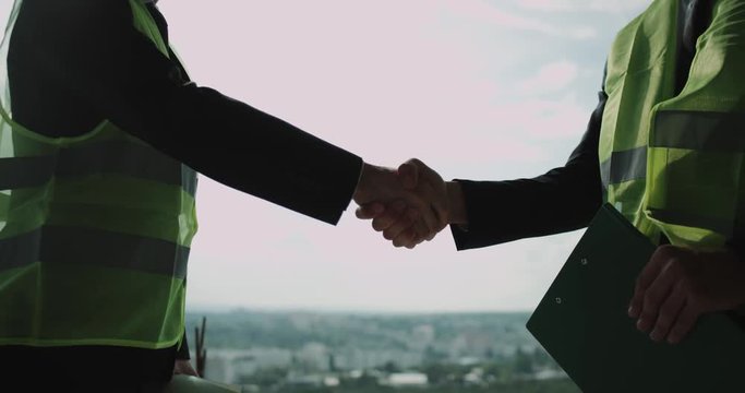 Construction building two business make a deal and holding hands.