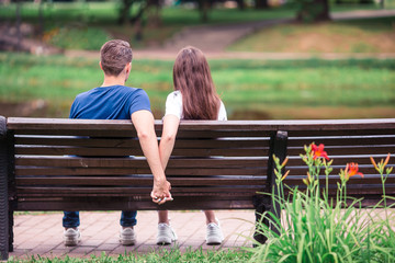 Relaxed young family on the bench in the park