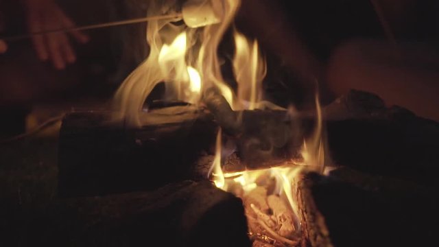 marshmallow over campfire with friends in slowmotion
