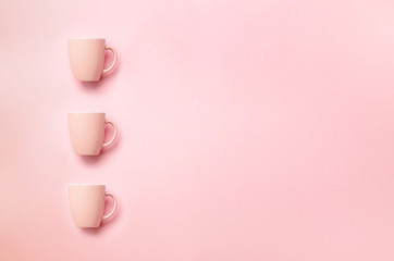 Row with pink cups over punchy background. Birthday party celebration, baby shower concept. Pastel colors pattern. Banner. Minimalist style design