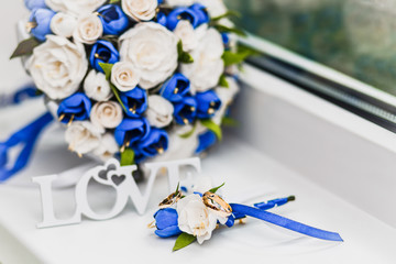 a bridal bouquet and a groom's boutonniere, on which were put wedding rings from gold