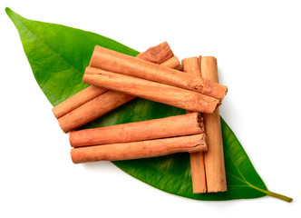 cinnamon sticks and fresh leaves isolated on the white background, top view