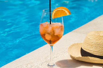 Cold glass of aperol sprit on a pool background