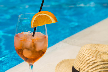 Cold glass of aperol sprit on a pool background