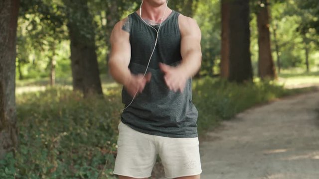 young man warming up before jogging in park