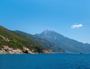 Fototapeta na wymiar Ship sailing across the Aegean Sea near mountain of Athos