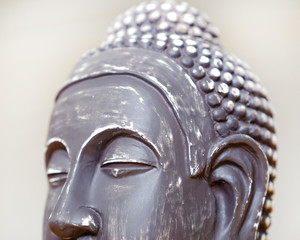 Buddha's face close-up. The Buddha image in ceramics. The texture of the background and focus of the soft focus.