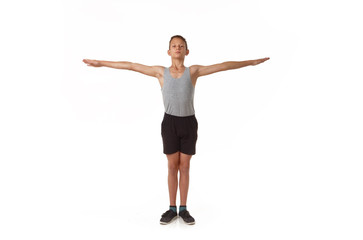 Teen in a T-shirt and shorts performs gymnastic exercises.