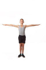 Teen in a T-shirt and shorts performs gymnastic exercises.