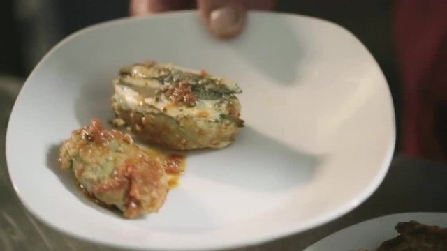 Polpette di pesce impiattate in un ristorante di lusso con basilico e olio extra vergine di oliva e sugo