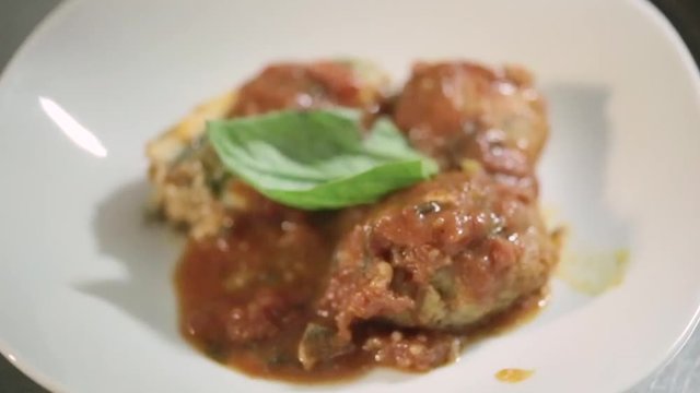 Polpette di pesce impiattate in un ristorante di lusso con basilico e olio extra vergine di oliva e sugo