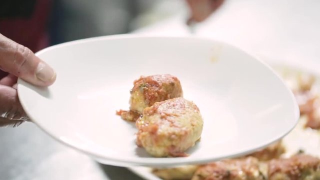 Polpette di pesce impiattate in un ristorante di lusso con basilico e olio extra vergine di oliva e sugo