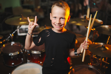 boy plays drums in recording studio