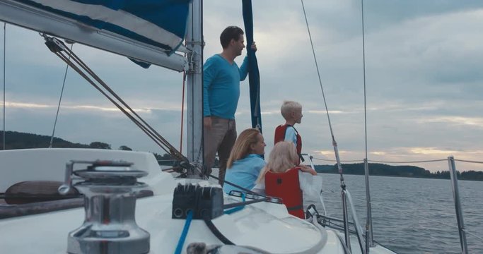Beautiful Caucasian family of mother, father and two kids boy and girl enjoying their boat trip. 4K UHD