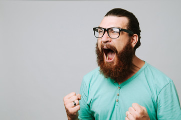 Screaming bearded man with eyeglasses over white background