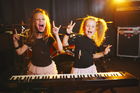 little girl play on synthesizer in music studio