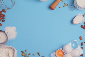 Baking ingredients for homemade pastry on blue background. Bake sweet cake dessert concept. Top view. Flat lay. Copy space. Toned