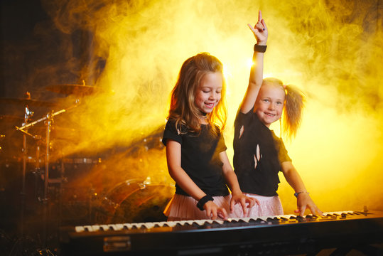little girl play on synthesizer in music studio