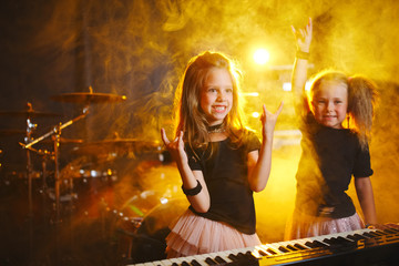 little girl play on synthesizer in music studio