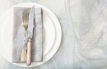 Holiday table place setting with plates, fork and knife, copy space
