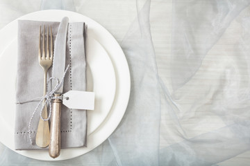 Holiday table place setting with plates, fork and knife, top view